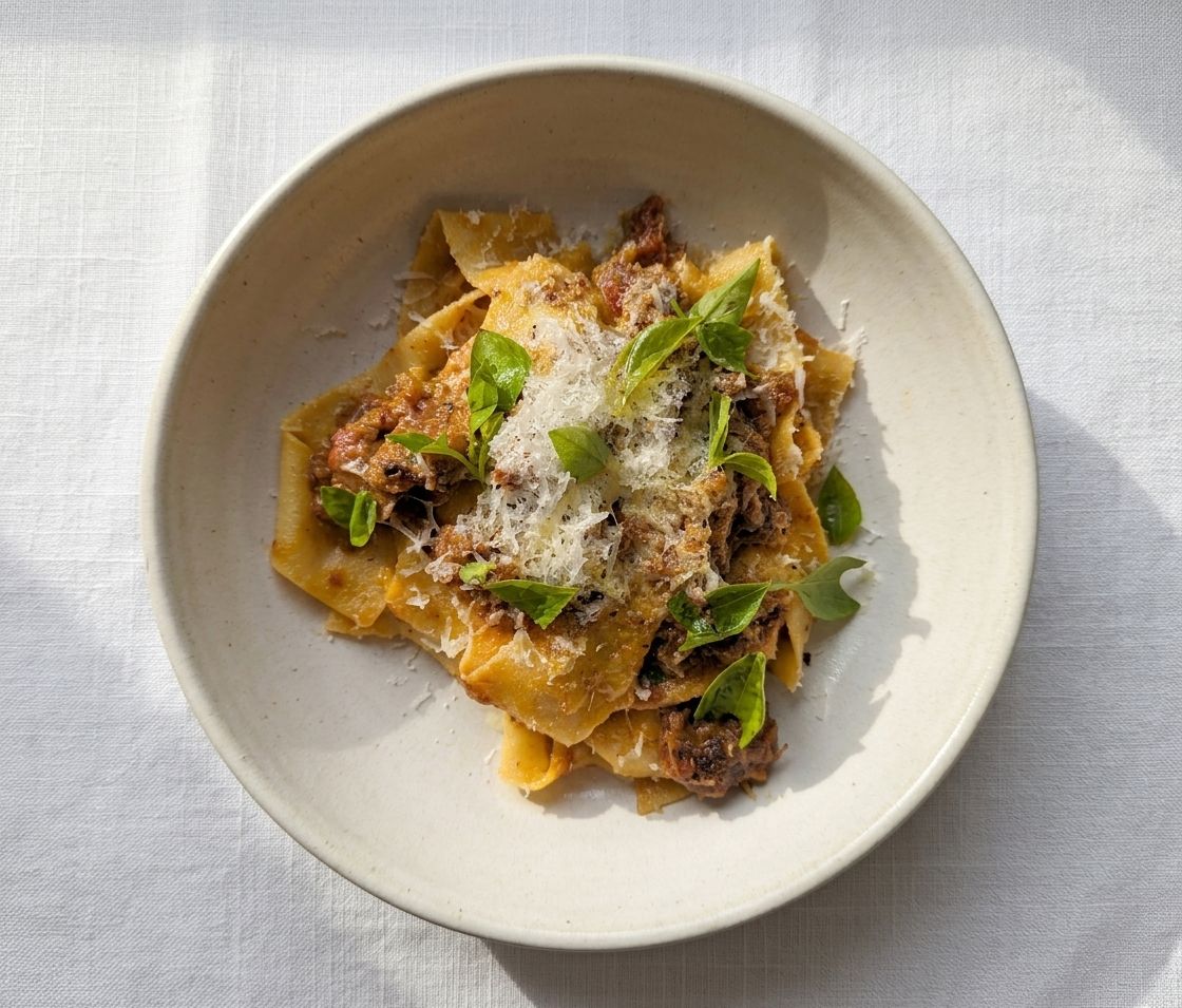 Pappardelle with ragu bolognese, parmesan and basil, rolled and cut by hand in a pasta class
